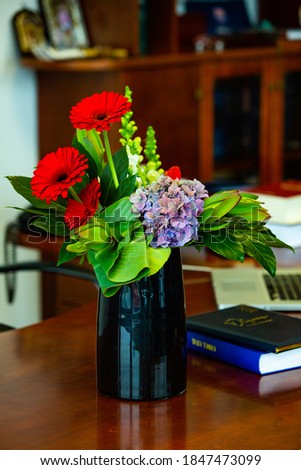 Working table with vase of flowers in modern office. Bouquet of flowers on a table in a modern room.