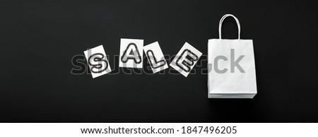 Sale text with white shopping paper bag on black background. Delivery mock up black on white craft paper bag package. Sale promotion discount. Long web banner with copy space
