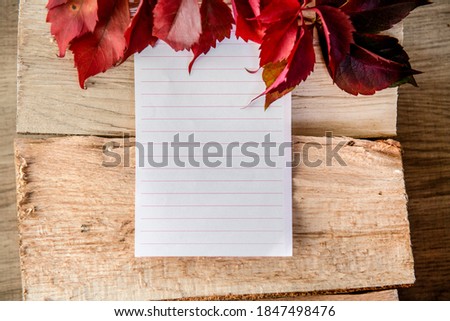 Autumn leaves and paper on the wood