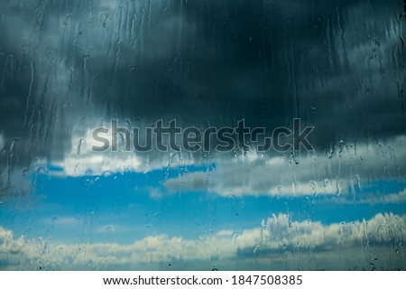 view through a window during rain. rainwater is running over the window panes. 