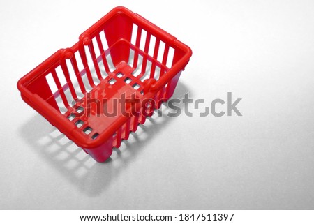 red empty plastic shopping basket isolated on blue background. top view.