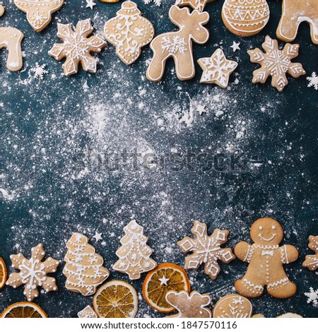 Christmas composition, New Year greeting card. Mockup with festive food decorations and gingerbread cookies on blue background. Copy space.