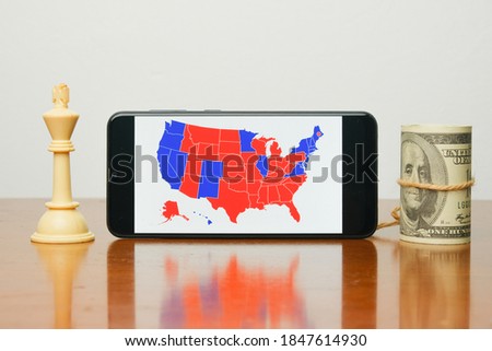 A picture of  US election map on smart phone with white king chess and fake dollar insight. People are waiting the outcome of US President 2020 Election.