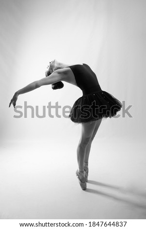 Slim young female dancer, dancing on tiptoe wearing a dress, studio, lifestyle