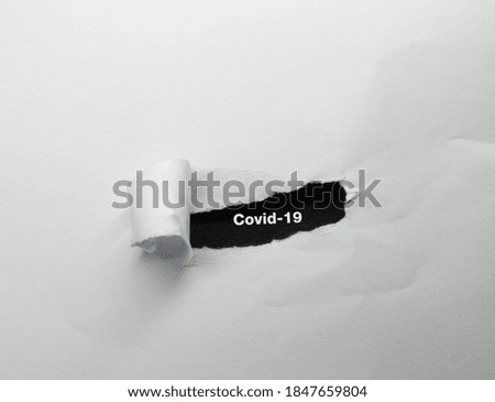 Covid-19 text peeled white paper n black background
