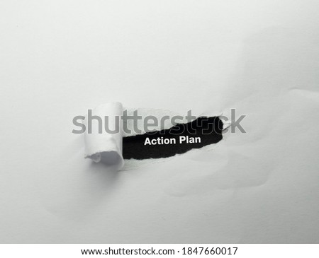 Action plan text written on peeled white paper on black backgroun