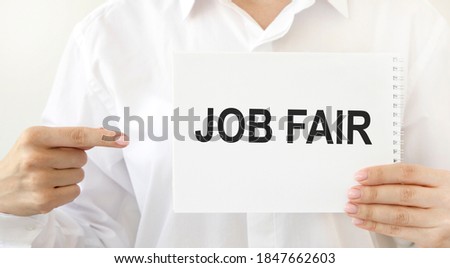 The girl points to a notepad with the text JOB FAIR.