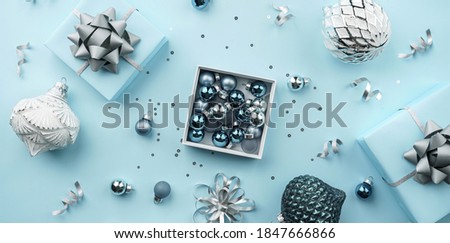 Merry Christmas card made of gift boxes, blue, white, silver decorations, bows, sparkles and confetti on blue background. Xmas and New Year holiday, bokeh, light. Flat lay, top view