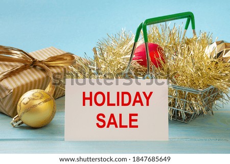 Shopping cart and text HOLIDAY SALE on white paper note list. Shopping list concept.