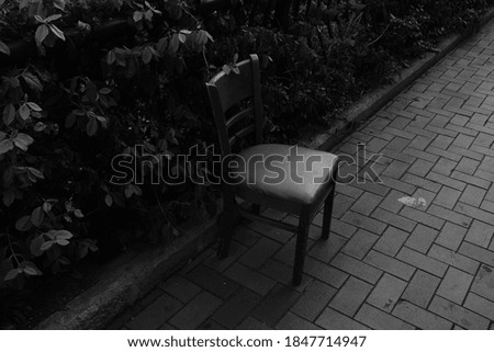 a black-and-white photograph of a chair on the street