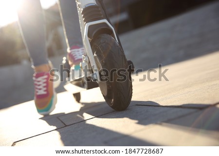 Woman riding electric kick scooter outdoors, closeup. Space for text Royalty-Free Stock Photo #1847728687
