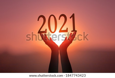 2021 concept: Hands hold  2021 against on sunset  background