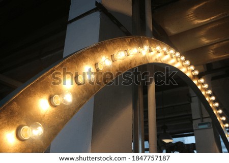 Vintage illuminated metallic rusty arc with glowing light bulbs on a rusty metal texture background..