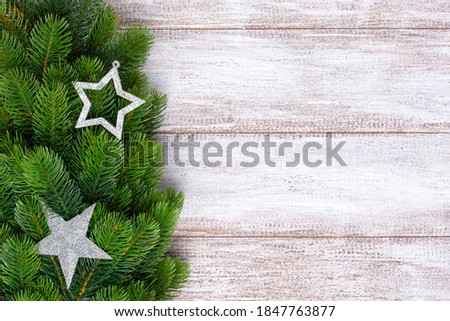 mock up, silver star and decorations on fir branches on a wooden background.