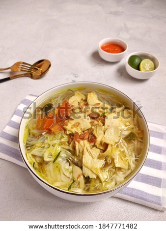 Soto ayam is a typical Indonesian food consisting of chicken slices, vermicelli, cabbage, tomatoes, drenched in yellow broth.
