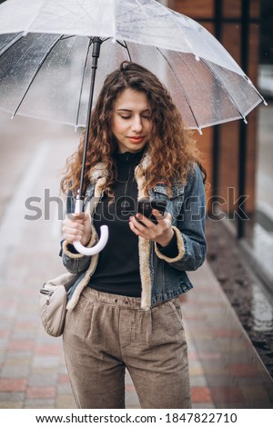 Woman walking under the umbrella in a rainy weather