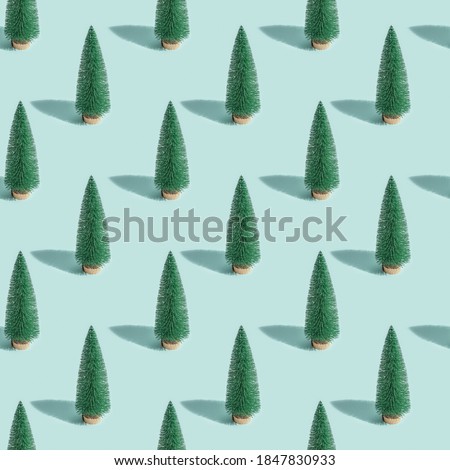 Christmas shining trees seamless pattern, green fir on pastel mint paper background. Winter Happy holidays. New Year minimal card