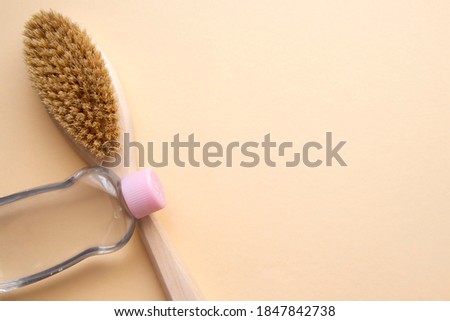 organic dry massage brush and bottle of body oil. Anticellulite massage. Spa beauty concept	
