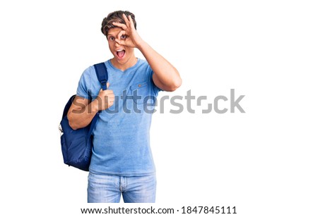 Young handsome man holding student backpack smiling happy doing ok sign with hand on eye looking through fingers 