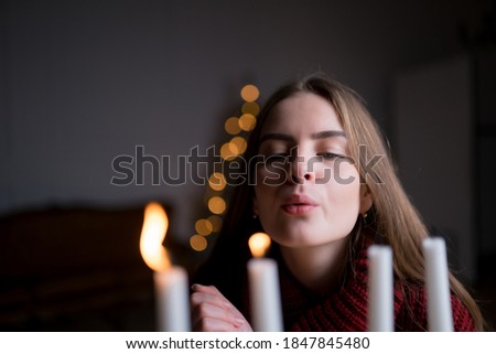 The girl blows out the Christmas candles. New year concept, holiday