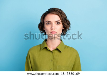 Photo portrait of calm pretty girl with short hair wearing green shirt isolated on blue color background