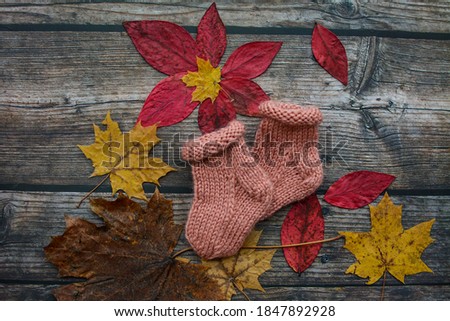 Soft and warm newborn socks on dark wooden background