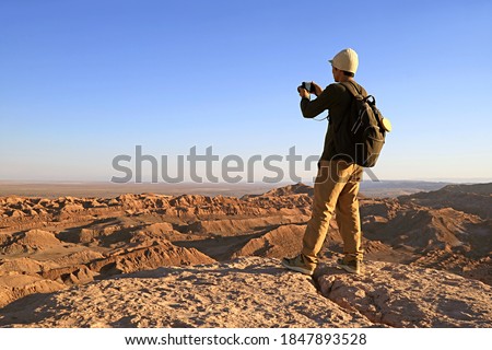 Traveler Shooting Photos on the Rocky Cliff of Valle de la Luna or the Moon Valley in Atacama Desert, San Pedro de Atacama, Northern Chile