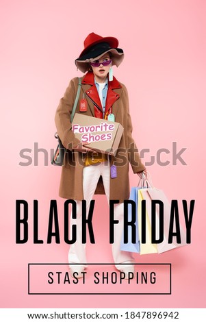 surprised woman in sunglasses and hats with sale tags holding box with favorite shoes and shopping bags near black friday lettering on pink