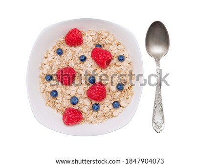 Oatmeal porridge with berries isolated on white background.