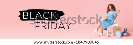 Young woman with laptop and new shoes on color background. Black Friday sale Royalty-Free Stock Photo #1847909845