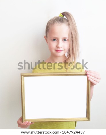 girl holding a frame for a photo or a frame for a banner, on a white background, children's advertising