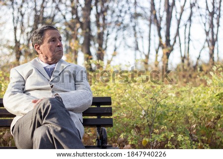 Senior man sitting on bench in the park 