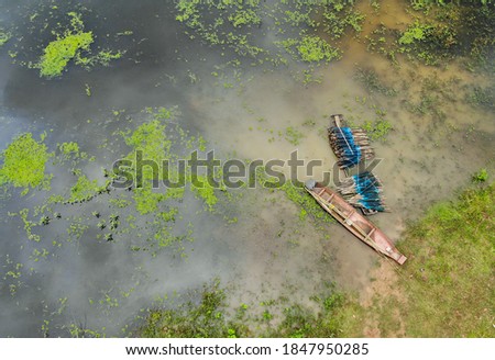 Top view of picture of an old wooden boat by the shore with equipment for fishing nets