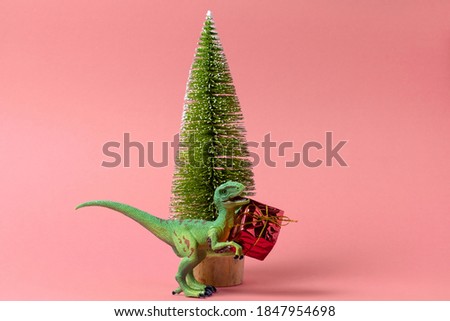 festive minimal greeting card with 
 cute dinosaur and Christmas tree on a pink background