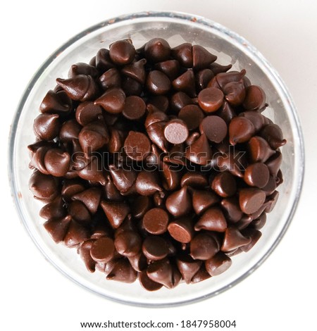 Chocolate chips or chocolate morsels are small chunks of sweetened chocolate, used as an ingredient in a number of desserts, in trail mix and less commonly in some breakfast foods such as pancakes. Royalty-Free Stock Photo #1847958004