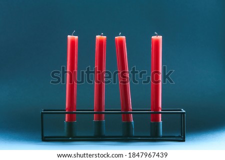 Candlestick with four red candles in the blue background. Christmas, romantic