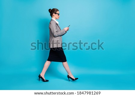 Full size profile side photo lady boss go copyspace use cellphone wear blazers skirt isolated blue color background