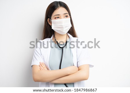 portrait of female doctor wearing a mask with her arms crossed
