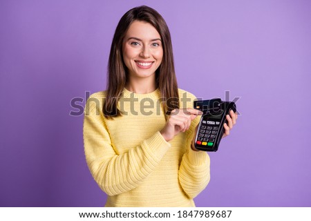 Photo portrait of happy glad woman paying with credit card holding terminal isolated on vivid purple colored background
