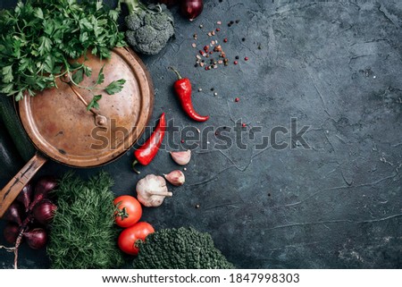Vegetarian cooking ingredients. Autumn harvest fair. Healthy, clean food cooking and eating concept. Copper pan, colorful autumn vegetables, pumpkin on dark background. Top view. Copy space