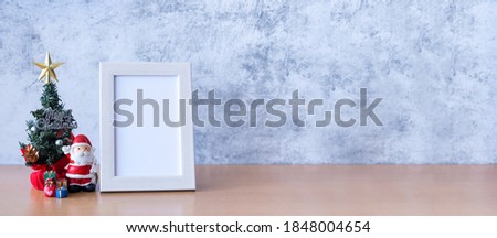 Picture frame and Christmas decoration - Santa Clause, tree and gift on wooden table. Christmas and Happy new year concept