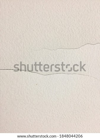 photo of a white wall with 2 crack lines