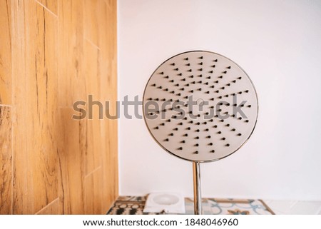 Shower head in the bathroom in the form of a tropical shower photographed against the white ceiling
