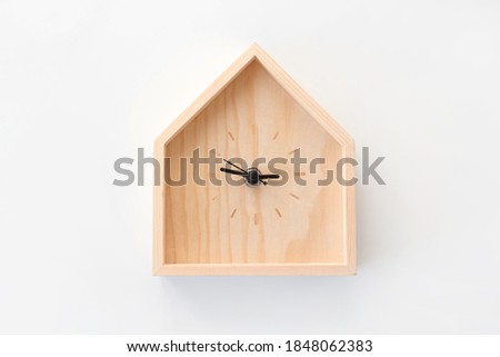 Wooden clock in the shape of house isolated on white background. Minimal concept. Flat lay. Top view.