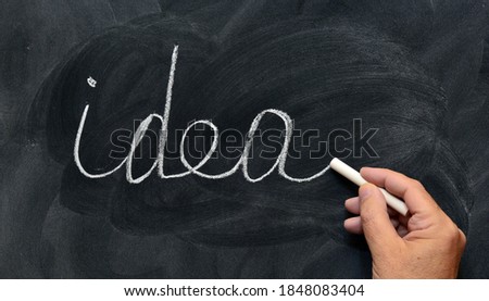 The word idea written by hand and with chalk on blackboard