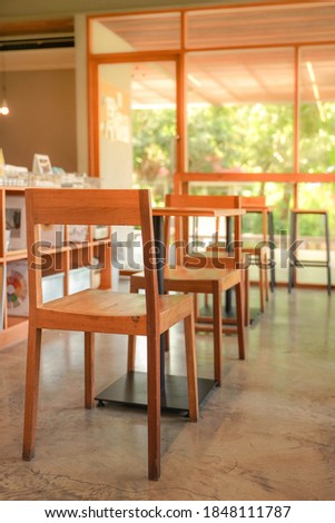 Cozy wooden interior of restaurant, copy space. Comfortable modern dining place, contemporary design background, available wooden chair and metal table in canteen or cafe