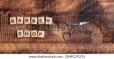 barbershop. inscription on a wooden background, scissors are located on the side.