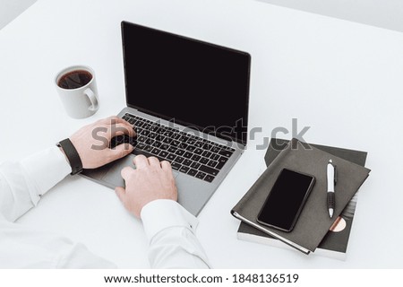 office man drinking coffee while working on laptop cellphone and note books