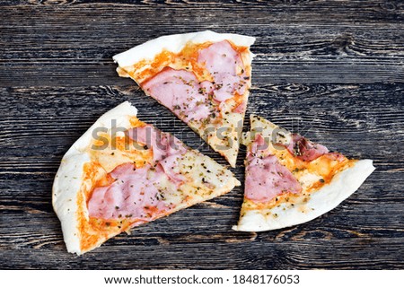 one pizza stuffed with ham, cheese, and herbs and other ingredients, inexpensive fast food , closeup unhealthy food