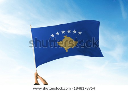 Kosovo flag holding hands in the air. Blue Sky Flag and Freedom